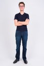 Full body shot of happy young handsome man with eyeglasses smiling Royalty Free Stock Photo