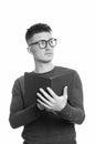 Studio shot of young handsome man holding book while thinking Royalty Free Stock Photo