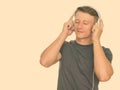 Studio shot of young handsome Caucasian man listening to music isolated against white background Royalty Free Stock Photo