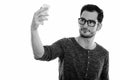 Studio shot of young handsome man taking selfie picture with mobile phone while wearing eyeglasses Royalty Free Stock Photo