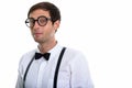 Studio shot of young handsome man wearing eyeglasses with suspen