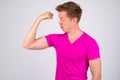 Young funny looking man making face while flexing muscles Royalty Free Stock Photo