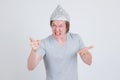 Angry young man wearing tin foil hat as conspiracy theory concept pointing finger