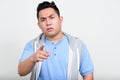 Portrait of stressed young overweight Asian man pointing at camera Royalty Free Stock Photo