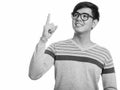 Studio shot of young happy Asian man smiling and pointing finger up while thinking Royalty Free Stock Photo