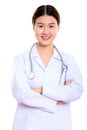Studio shot of young happy Asian woman doctor smiling with arms Royalty Free Stock Photo