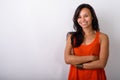 Studio shot of young happy Asian woman smiling with arms crossed Royalty Free Stock Photo