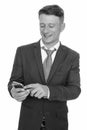 Studio shot of young happy Caucasian businessman using mobile phone isolated against white background Royalty Free Stock Photo