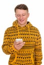 Studio shot of young happy Caucasian man using mobile phone isol Royalty Free Stock Photo