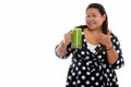 Studio shot of young happy fat Asian woman smiling while holding Royalty Free Stock Photo