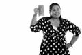 Studio shot of young happy fat Asian woman smiling while raising glass of vegetable smoothie Royalty Free Stock Photo