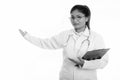 Studio shot of young happy fat Persian woman doctor smiling while holding clipboard and showing something Royalty Free Stock Photo