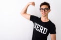 Studio shot of young happy nerd man smiling while flexing arm an Royalty Free Stock Photo