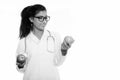 Studio shot of young happy Persian woman doctor smiling while holding red apple and looking at green apple Royalty Free Stock Photo