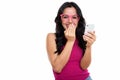 Studio shot of young happy Spanish woman smiling while holding m