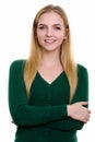 Studio shot of young happy teenage girl smiling with arms crosse Royalty Free Stock Photo