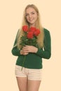 Studio shot of young happy teenage girl smiling while holding red roses ready for Valentine& x27;s day Royalty Free Stock Photo
