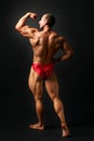 Studio shot of young male bodybuilder pose on black background, Royalty Free Stock Photo