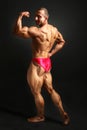 Studio shot of young male bodybuilder posing, looking back over