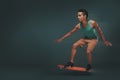 Studio shot of a young man riding a skateboard isolated on dark background