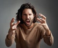 Youre making my blood boil. Studio shot of a young man screaming in anger against a gray background. Royalty Free Stock Photo