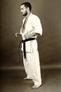 Studio shot of young man in white kimono and black belt Royalty Free Stock Photo