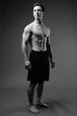 Studio shot of young muscular handsome man shirtless in black an Royalty Free Stock Photo