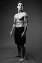 Studio shot of young muscular handsome man shirtless in black an Royalty Free Stock Photo