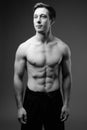 Studio shot of young muscular handsome man shirtless in black an Royalty Free Stock Photo