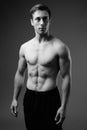 Studio shot of young muscular handsome man shirtless in black an Royalty Free Stock Photo