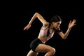 Studio shot of young muscular woman running isolated on black background. Sport, track-and-field athletics, competition Royalty Free Stock Photo