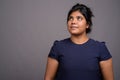 Young overweight beautiful Indian woman against gray background Royalty Free Stock Photo