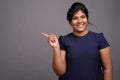 Young overweight beautiful Indian woman against gray background Royalty Free Stock Photo