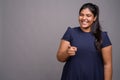 Young overweight beautiful Indian woman against gray background Royalty Free Stock Photo