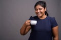 Young overweight beautiful Indian woman against gray background Royalty Free Stock Photo