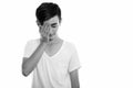 Studio shot of young stressed Persian teenage boy covering his face Royalty Free Stock Photo