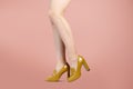 Studio shot of a young woman`s legs in a pair of yellow high heeled loafers Royalty Free Stock Photo