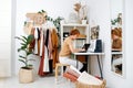 Girl tailor sitting at a table with laptop and sewing machine