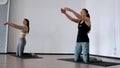 In the studio, two girls are engaged in pilates. Standing on their knees deviate back training the front of the thigh