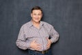 Portrait of happy satisfied man putting hands on his fat stomach Royalty Free Stock Photo