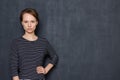 Portrait of serious focused young woman holding arm on waist Royalty Free Stock Photo