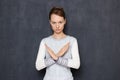 Portrait of serious focused young woman making cross with hands Royalty Free Stock Photo