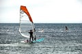 Studland, Dorset, England - June 01 2018: Holidaymakers swimming, windsurfing, kayaking and paddle boarding in the sea on the Sout