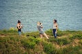 Studland, Dorset, UK - June 04 2018: Three young women taking cellphone photos of each other on a coastal headland