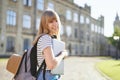 Study abroad. Happy university student with laptop in campus