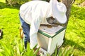 The study of bees is known as melittology. This Beekeeper is ready to check on the bee hive while wearing protective clothing