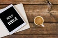 Study digital Holy Bible with a cup of coffee on a wooden table Royalty Free Stock Photo