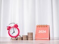 Study goals, 2024 Desk calendar, Red alarm on stack of coins. The concept of saving money and manage time for education, student Royalty Free Stock Photo