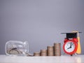 Study goals, Red alarm with graduation hat, Glass bottle and stack of coins. The concept for Resolution, Goal, Action, Planning, Royalty Free Stock Photo