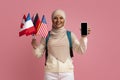 Study Languages Online. Muslim Female Student Holding International Flags And Blank Smartphone Royalty Free Stock Photo